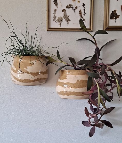 This duo of planters is the perfect artistic way to display your houseplant. Hang them on a wall or in front of a window. All hanging planters include a drainage hole at the bottom. Watering tips are included with purchase. Planters are hand-made on a pottery wheel.  Note: purchases do not include the plant. Purchases only include the ceramic hanging planter and mounting string/wire if relevant. This purchase includes BOTH hanging planters, as they come as a pair. *Handmade pottery is an artform Wall Hanging Vase, Plant Pot Ceramic Ideas, Wall Hanging Pottery, Ceramic Hanging Planter, Handmade Plant Pots, Pottery Wall Hangings, Pottery Wheel Ideas, Hanging Ceramics, Colorado Apartment