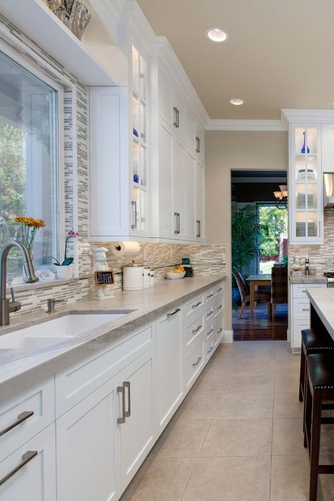 Sea Pearl quartzite countertop design ideas are to make it with white cabinet color and beige natural stone floor tiles. #seapearlquartzite #seapearlquartzitecountertop #seapearlquartzitekitchencountertop #seapearlquartzitekitchencounter #seapearlquartzitetops #quartzitecounter #whitecabinet #whitekitchencabinet #whiteshakercabinet #mosaictilebacksplash #creamfloortile #seapearlgreenquartzite #lessmaintenancekitchencountertop #maintenancefreekitchencounter #whitekitchen #naturalquartzitestone White Kitchen Cabinets With Cream Countertops, White Kitchen With Beige Floor Tiles, White Cabinets With Tile Floor, Cream Kitchen With White Cabinets, White Kitchen Cabinets Cream Tile Floor, White Kitchen Cabinets Beige Tile Floor, White Cabinets With Tile Flooring, Kitchen Design With Tile Floors, Beige Flooring Kitchen