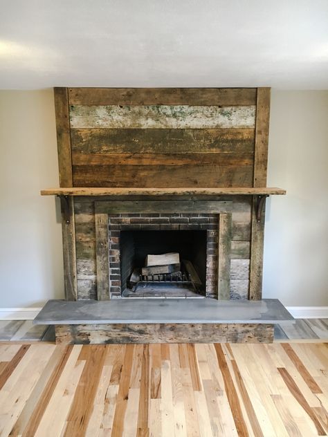 Just finished our remodel. Hickory flooring, concrete hearth and barn wood fireplace #barnwood Wood Hearth Fireplace, Reclaimed Wood Fireplace Surround Farmhouse, Barnwood Fireplace, Reclaimed Wood Fireplace Surround, Western Fireplace, Barn Fireplace, Fireplace Hearth Ideas, Rustic Farmhouse Fireplace, Reclaimed Wood Fireplace