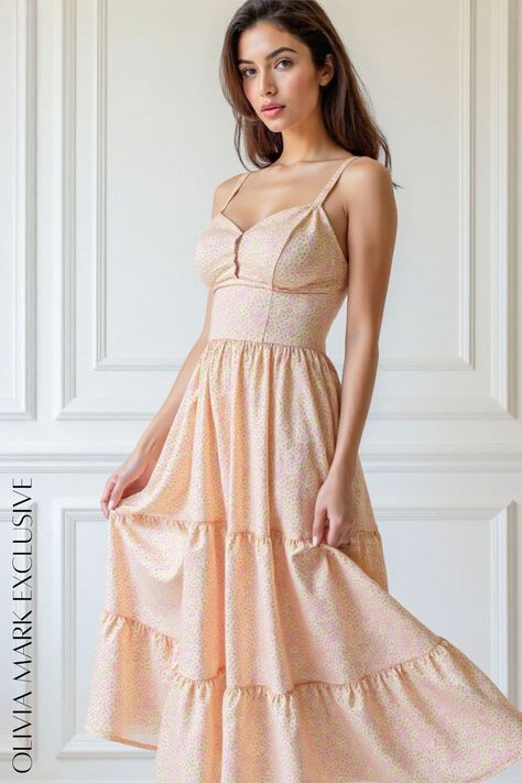 Its soft peach hue, adorned with a subtle floral pattern, whispers of springtime romance. The fitted bodice, with its sweetheart neckline and button detailing, accentuates the silhouette gracefully. Flowing into a tiered skirt, each ruffled layer adds a touch of ethereal beauty, creating a dreamy, bohemian charm. This dress is not just an article of clothing; it's a celebration of the feminine form, a piece that invites you to dance with the seasons and let your inner beauty shine. Peach Floral Print Maxi Sundress, Chic Peach Floral Print Maxi Dress, Feminine Peach V-neck Dress, Peach Sleeveless Floral Print Mini Dress, Tiered Sundress, Peach V-neck Summer Dress, Peach Blossom, Peach Blossoms, Inner Beauty