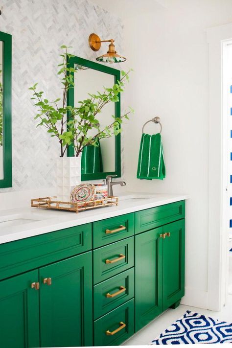 This gorgeous green-and-white bathroom is a preppy dream! Two mirrors and a double vanity make it easy for a pair of people to prepare for their day. Farmhouse-style fixtures light up the space, while a blue-and-white throw rug provides a bright contrast to the kelly green cabinets and accents. Blue And White Rug, Green Homes, Neutral Bathroom, Bad Inspiration, Green Stuff, Forest Bathing, Decor Baie, Modern French, Green Cabinets