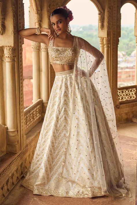 White attached cancan lehenga with floral brocade pattern, highlighted with sequins, zari, thread work. Paired with a padded blouse with floral embroidery using zari, sequins, thread work. Comes along with a dupatta with embroidered buttis. Components: 3 Pattern: Embroidery Type Of Work: Thread, Zari, Stones, Floral Neckline: Square Neck Sleeve Type: Sleeveless Fabric: Brocade Color: White Other Details:  Model height: 5ft 9inches, wearing size 32 Length: Lehenga: 42 inches Crystal embellished hem on blouse Note: All the jewellery worn by the model is not for sale Occasion: Destination Wedding,Bride - Aza Fashions Wedding Chaniya Choli, Lehenga White, Brocade Embroidery, Cancan Lehenga, Brocade Lehenga, Bridesmaid Lehenga, Indian Bridesmaids, Brocade Pattern, White Lehenga