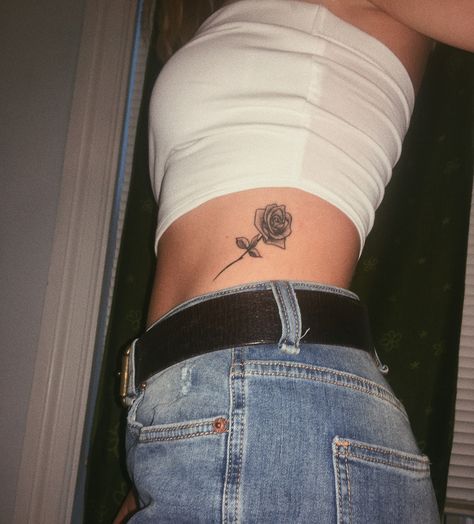 rose tattoo on ribs Stomach Rose Tattoo, Rose Tattoo On Ribs, Back Rib Tattoo, Rose Rib Tattoos, Cute Meaningful Tattoos, Tattoo On Ribs, Watercolor Dandelion, Rib Tattoo Placements, Small Rib Tattoos