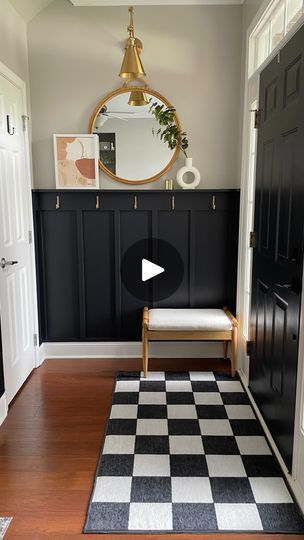 60K views · 8.1K reactions | The entryway reveal you’ve all been waiting! In case you missed it, let me catch you up: We added custom board and batten to define this entry way, painted it in “very black” by valspar, added gold wall hooks, a wall mirror, and a gold wall sconce. @breanneockeyhiser made some DIY custom wall art that I helped her build a frame for and we added that to the shelf we included in the board and batten build. We added a small bench for functionality and the cutest washable checkered rug to hide the outdated floor tile!  Let us know what you think in the comments and don’t forget to hit that follow button for more DIY’s like this!  #boardandbatten #custombuild #customhome #diyproject #diyprojects #interiordesign #diyhacks #diyidea #entryway #entrywaylighting #entrywa Board And Batten Entry Wall With Hooks, Dark Board And Batten Entryway, Black And White Board And Batten, Foyer Board And Batten Entryway, Tiny Entryway, Shaker Wall, Build A Frame, Board And Batten Wall, Entry Wall