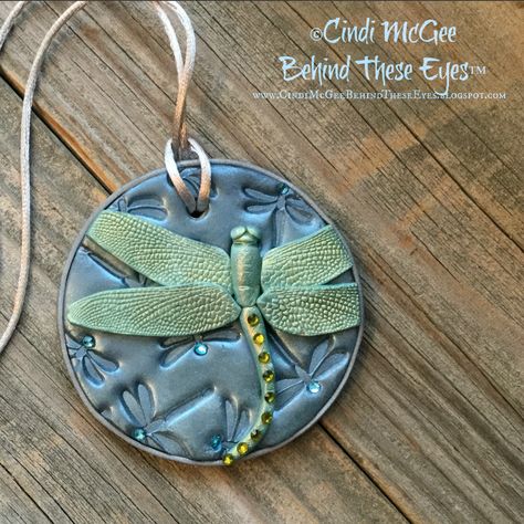 Cindi McGee created this shimmering dragonfly pendant using some of the awesome products in the Dragonfly Dreams Create Along Box!  She used the Dragonfly Deco Disc Stamp to create the wings for her dragonfly.  The shimmering blue mica powder and tiny gemstones from the kit added an extra bit of color and sparkle.  Cindi also has 3 more projects she's working on using the silkscreen, Magic Transfer Paper and the orange texture stamps from this kit! So many creative options in one box!   Would y Dragonfly Pottery, Clay Pendants, Polymer Clay Animals, Polymer Clay Jewelry Diy, Polymer Crafts, Clay Jewellery, Dragonfly Pendant, Green Hand, Polymer Jewelry