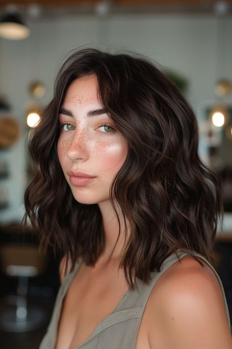 Woman with wavy brown hair and freckles in a stylish, indoor setting. Natural Hair Color For Brunettes, Brunette Glaze Hair, Natural Dark Hair Color Ideas, Chocolate Brown Toner, Hair Gloss Brunette, Dark Brown Hair With Front Highlights, Different Brunette Hair Colors, Balayage Front View, Chestnut Highlights On Dark Hair