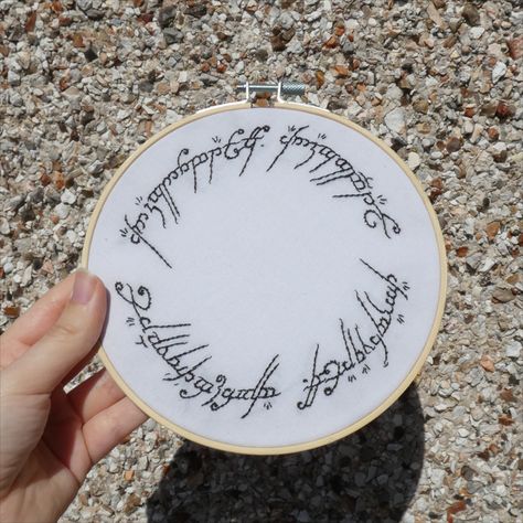 The perfect gift for a Lord of the Rings fan. This handmade embroidery hoop art of the one ring to rule them all text is embroidered by hand on white fabric in a 6-inch hoop. The back is finished neatly and the back of the embroidery is not visible. This hoop art can be easily hung from a wall or simply propped up. Lord Of The Rings Embroidery Pattern, Nerdy Embroidery Patterns, Lord Of The Rings Embroidery, Geeky Embroidery, Nerdy Embroidery, The One Ring, Text Embroidery, Handmade Embroidery, Embroidery Hoop Art