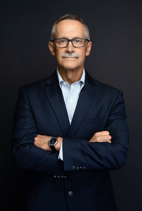 Business headshot of mature man wearing glasses with arms crossed smiling. Headshots For Pastor, Ceo Headshots Business Portrait Men, Standing Headshot Poses Men, Ceo Portraits Men, Studio Corporate Portrait, Corporate Photography Men, Husband Wife Business Photoshoot, Real Estate Portraits Men, Corporate Shoot Ideas