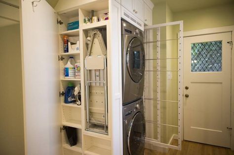 A door conceals the mounted ironing board and storage. Drying racks slide out; clothes can be hung over the rails. Pull Out Dryer Rack, Cabinets Over Sink, Mounted Ironing Board, Concealed Laundry, Pull Out Ironing Board, Clothes Cabinet, Drying Racks, Drying Rack Laundry, Over Sink