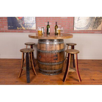 Create a space that is as beautiful as it is functional with our Wine Barrel Table Set. Handcrafted in the USA, this table set showcases a retired wine barrel base. A cabinet door in the base reveals a barrel head lazy susan shelf. The round tabletop is crafted of four wine barrel heads with original French stamps. Included, four backless stools complete the set | Napa East Collection Cabinet Base Wine Barrel Round Top Table Set Wood in Brown | Wayfair Whiskey Barrel Table, Wine Barrel Bar, Round Pub Table, Wine Barrel Table, Cabinet Base, Barrel Bar, Wine Barrel Furniture, Barrel Table, High Top Tables