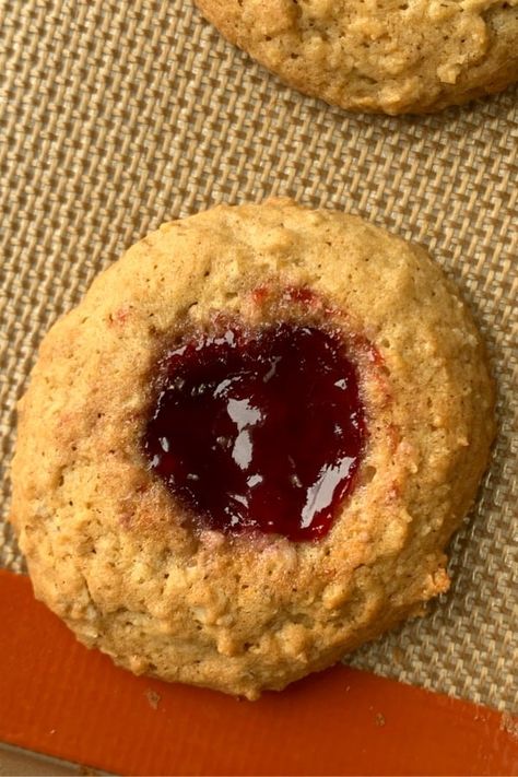 Red raspberry jam filled cookie on baking sheet Oatmeal Thumbprint Cookies Jam, Oatmeal Jam Cookies, Oatmeal Raspberry Cookies, Oatmeal Thumbprint Cookies, Archway Cookies, Berry Bars, Sweet Oatmeal, Oatmeal Lace Cookies, Raspberry Thumbprint