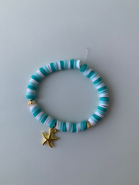 Handmade blue and white clay bead bracelet with gold beads and golden starfish. Beach Clay Bead Bracelets Ideas, Clay Bead Bracelet Ideas Starfish, Clay Bead Color Combos Beach, Clay Beads Beach Vibes, Beach Bracelets Aesthetic Clay Beads, Teal Clay Bead Bracelet Ideas, Moana Clay Bead Bracelet, Ocean Themed Clay Bead Bracelets, Seashell Clay Bead Bracelet