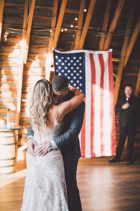 An American flag waves behind the bride and groom for the first dance of their military wedding. #weddingphotos #virginiawedding #barnwedding #weddingreception #rusticwedding #farmwedding #weddingvenue #48fields #weddingideas #firstdance #militarywedding #southernwedding #countrywedding American Themed Wedding, Army Wedding Ideas, Army Wedding Pictures, Military Wedding Army, Red White Blue Wedding, Americana Wedding, Military Background, Army Wedding, Wedding Flags