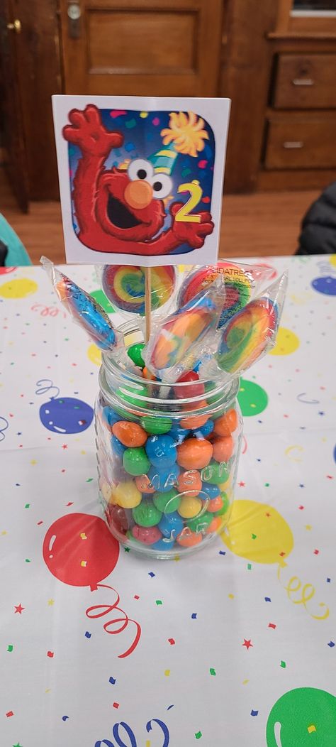 I used a Mason jar, lollipops, and peanut M&Ms. I found the Elmo online and printed it, added a skewer, then glued them together. Elmo Birthday Centerpieces Ideas, Elmo Centerpiece Ideas, Sesame Street Baby Shower Ideas, Sesame Street Centerpiece Ideas, Diy Elmo Birthday Party, Elmo Centerpieces, Sesame Street Centerpiece, Elmo World, Smash Cakes