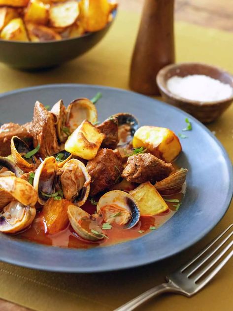 This popular Portuguese dish of pork with clams and fried potatoes, also known as porco alentejana, is rich, flavorful, and oh-so-satisfying. #pork #clams #portuguese Portuguese Pork Stew, Portuguese Pork And Clams, Portugese Pork Recipes, Portuguese Pork And Potatoes, Pork Alentejana Recipe, Carne Alentejana Portuguese, Portuguese Meals, Portuguese Seafood, Culinary Dishes