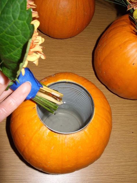 Carve out the center of a pumpkin, insert a soup can, and place flowers inside for an expensive looking (yet cheap) DIY fall centerpiece. Pumpkin Vase, Vase Diy, Pumpkin Flower, Dalian, Pumpkin Decor, Fall Party, Deco Floral, Garden Care, Fall Holidays