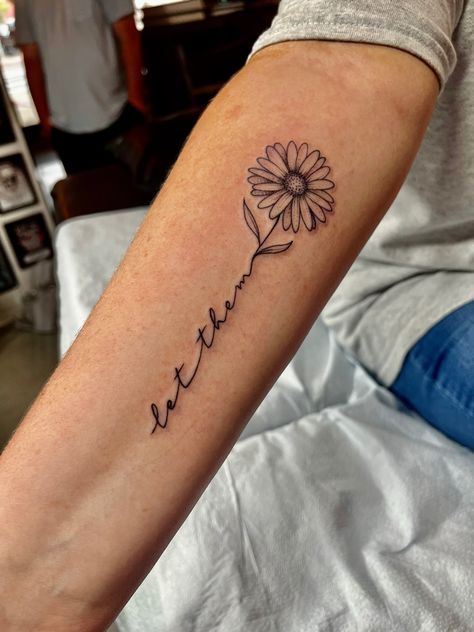 Grace Wrist Tattoos For Women, Let Them Sunflower Tattoo, 1 Word Tattoos For Women, Sunflower Tattoo With Name In Stem, You Saved Me Tattoo, Tattoos For Side Of Arm, Let Them Flower Tattoo, Tattoos Sunflower Small, Single Sunflower Tattoo