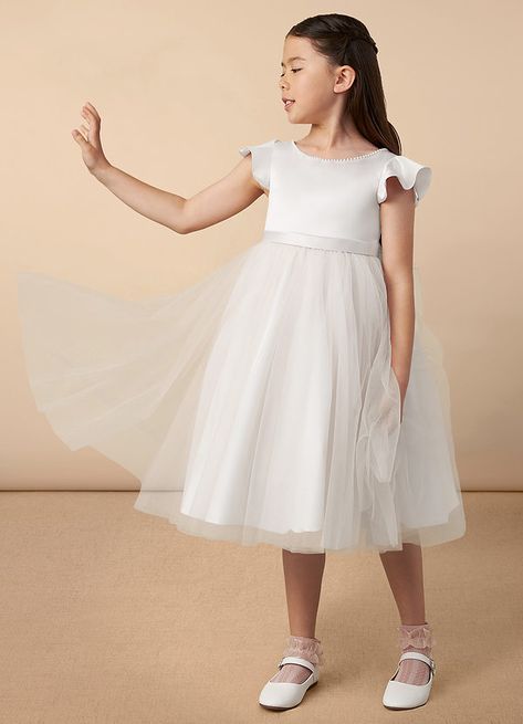 Aster is our lovely satin and tulle A-line flower girl dress. She features adorable flutter cap sleeves, a scoop neckline, a V-back, and a beautiful bow at the back of the dress. Tea Length Flower Girl Dress, Tea Length Tulle, Camilla Dress, Whimsical Dress, Aster Flower, Ivory Flower Girl, Ivory Flower Girl Dresses, First Communion Dress, Ivory Flower