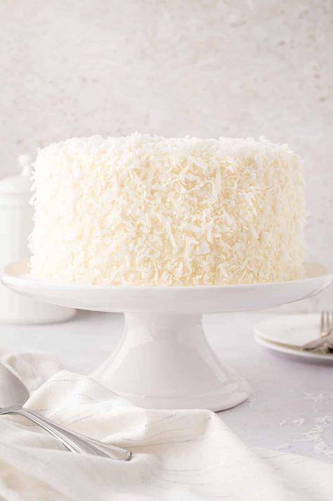 An 8-inch coconut cake on a cake stand. Ina Garten Coconut Cake, Taco Bell Recipes, Coconut Buttercream, Cake Rolls, Coconut Cake Recipe, Ina Garten Recipes, Coconut Frosting, Make Cream Cheese, Coconut Cake