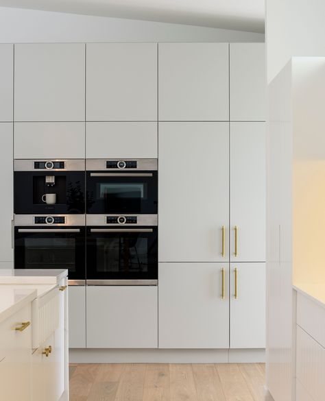 Stainless steel integrated wall oven appliance tower with white joinery, brass handles, and warm wooden oak floor planks. Featuring a white Farmhouse Butler's Sink, push-to-open cabinetry, and gold knob and pull joinery handles. Appliance Tower, Oven Tower, Oven Appliance, Integrated Oven, Custom Kitchens Design, Joinery Design, Newcastle Nsw, Interior Design Games, Ultimate Kitchen