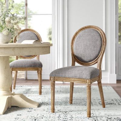 This set of two side chairs adds a few more seats in your living room when you have guests — and it can also feel right at home at your kitchen nook or dining room table. These chairs have a solid pine wood frame in a light brown finish, with turned, chamfered legs and additional carved details. The solid round backs feature a linen-upholstered inset along with the seat. Both are filled with foam to provide additional support as you enjoy brunch or conversation with family and friends. Hand-cura Round Back Dining Chairs, Farmhouse Table Chairs, Kelly Clarkson Home, Solid Wood Sideboard, Chair Wood, Upholstered Side Chair, Wood Sideboard, Upholstered Fabric, Kelly Clarkson