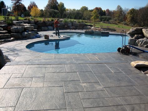 PA slate pattern. Cantilever-style pool decking, no coping (seamless transition where decking meets pool). Far-end of pool deck has upper level for future pool house or cabana. Pool Decking Concrete, Decks Around Pools, Pool Decking, Inground Pool Landscaping, Concrete Patio Makeover, Concrete Patio Designs, Types Of Concrete, Pool Renovation, Pool Remodel