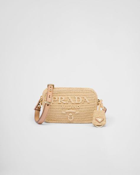 This shoulder bag with sleek, minimalist lines is made of raffia, a light, natural material with a summery mood. Prada's emblematic lettering logo is transformed into a large detail in relief that decorates the front. The adjustable, removable leather shoulder strap completes the design. Prada Raffia, Raffia Crochet, Crochet Shoulder Bag, Prada Shoulder Bag, Womens Designer Handbags, Triangle Logo, Resort Collection, Metallic Logo, Metal Hardware