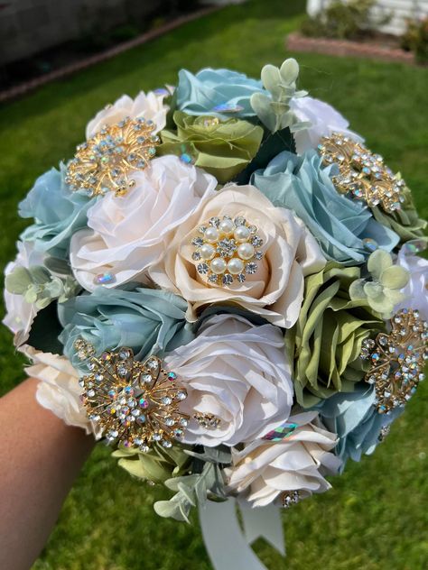 Handmade Quinceañera Bouquet/ Wedding.  With Light Sage, Ivory, Sage Green and Champagne Roses. Finished off with Gold brooches.  *Please note brooches can change in style due to availability.* Decor / color combinations can be changed upon request. {This is a made to order Bouquet} Sage Green Quinceanera Ramo, Sage Green And Champagne Wedding, White And Gold Wedding Themes, Quinceanera Bouquet, Sage Green Flowers, Quince Themes, Gold Bouquet, Simple Wedding Bouquets, Sage Green Floral