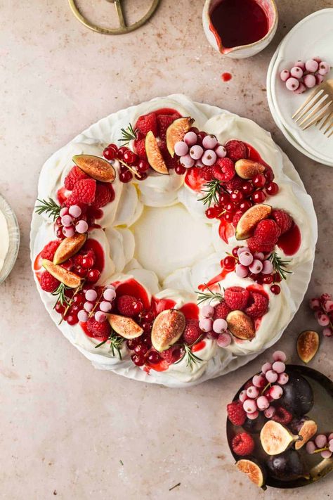 This show-stopping Christmas Pavlova Meringue Wreath is deceptively simple to make. Crisp meringue with a pillowy interior is topped with whipped cream and fresh fruit. A stunning dessert. Christmas Pavlova Recipe, Christmas Pavlova Wreath, Pavlova Wreath, Gluten Free Christmas Desserts, Christmas Pavlova, Holiday Baking List, Christmas Dessert Table, Meringue Desserts, Raspberry Coulis