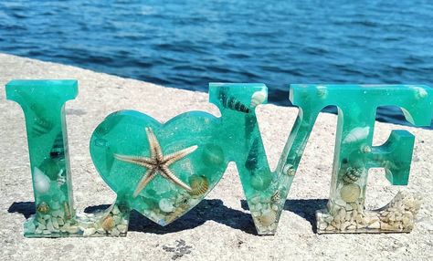 #Handmade #Resin #LOVE #sign #Lovesign #starfish #seashell #shell #Ocean #Sea #decor #ValentinesDay #green #blue 🌴 This sign with the word LOVE in 3D is made with epoxy resin, natural pigments and many sea elements from Gandía beach (Valencia, Spain), such as shells, stones from the beach, seashells and a starfish. It's a unique and original piece, there is only one! Sea Elements, Resin Business, Beach Seashells, Handmade Gifts For Men, Easy Handmade Gifts, Condo Remodel, Handmade Gifts Diy, Love Decor, Beach Stuff