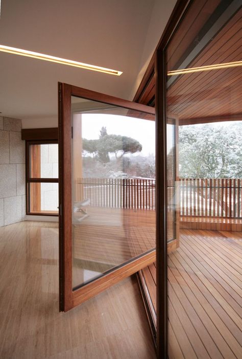 Large wood framed windows rotates open onto wooden front balcony. Studio Dwelling / cmA Arquitectos. Fasad Design, Pivot Door, Garage Studio, Sliding Glass Doors, White Cottage, Window Door, Design Del Prodotto, Decoration Inspiration, Entrance Doors