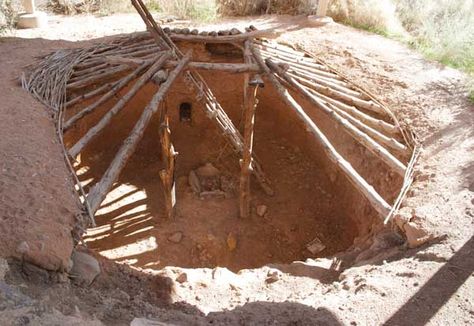 This is a recreation of an Anasazi Pit House in Mesa Verde, Colorado. Evidence of the subterranean quarters dates back to around 500 AD. These dwellings were shallow, around 3-5 feet deep. The roof canopy, usually flat, was held up generally by four posts- positioned upright whose structure join was joined at the top by four horizontal beams and crossed with ceiling joists. The exterior of the pithouse was made of branches, brush and grass held together with mud. Construction was completed with Pit House, Bushcraft Shelter, Off Grid Survival, Earth Sheltered, Survival Skills Life Hacks, Underground Homes, Indian Village, Survival Life Hacks, Bushcraft Camping