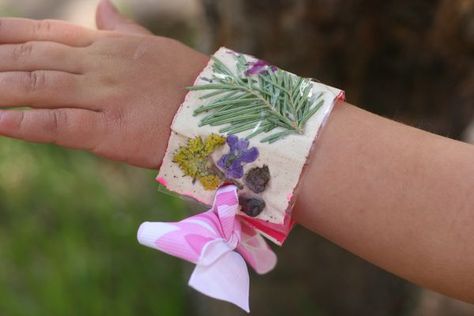 I know there are several tutorials for nature bracelets out there. Why not one more, right? Here's my version of making a nature bracelet. SUPPLIES Scissors Clear packing tape Duct tape Ribbon Gathered natural treasures STEP 1: Gather up some natural treasures: flowers, petals, pine needles, pieces of pinecone, etc.... Duct Tape Bracelets, Camping Craft, Camping Activity, Trip Design, Nature Hike, Flowers Ribbon, Nature Craft, Camp Crafts, Ribbon Bracelet