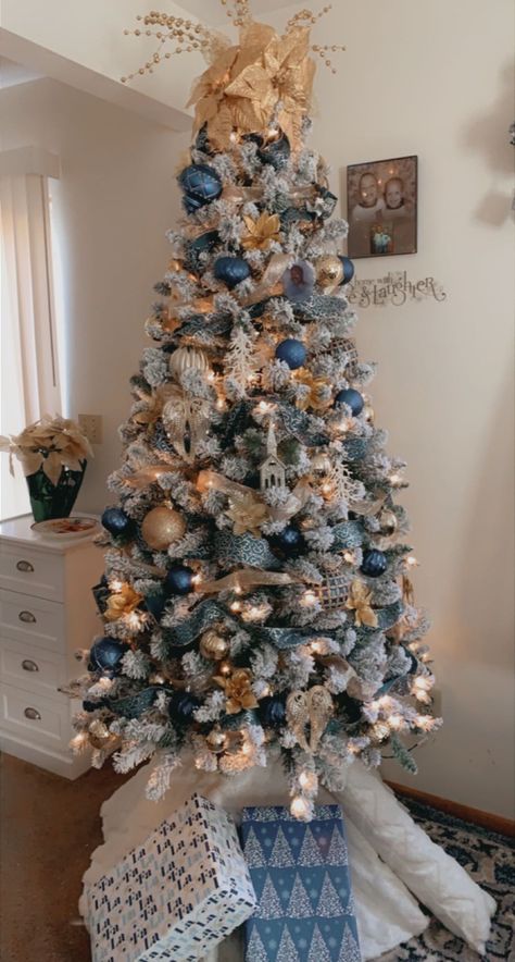 Blue/gold decorated Christmas tree . Blue and gold decor Flocked Christmas Trees Decorated Blue And Gold, Light And Dark Blue Christmas Tree, Blue Flocked Tree, Blue Silver Copper Christmas Tree, White Blue And Gold Christmas Tree, Christmas Tree Themes Colors Blue And Silver, Blue White Silver Gold Christmas Tree, Blue Gold And White Christmas Decor, Blue And Rose Gold Christmas Decor