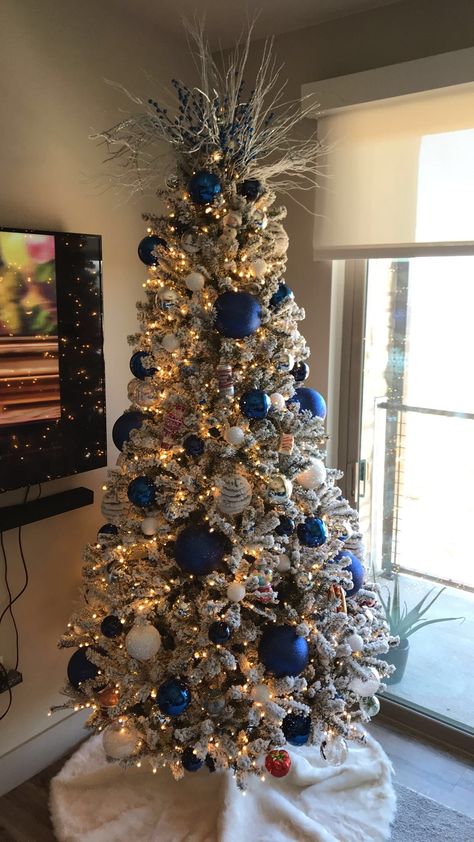 Flocked Christmas Trees Decorated Blue And Silver, Blue Christmas Lights On Tree, Christmas Tree Royal Blue, Christmas Tree Ideas White And Blue, Flocked Tree Blue Ornaments, Blue Black Silver Christmas Decorations, Dark Blue Ornaments Christmas Tree, Red White Blue Gold Christmas Tree, Blue And Silver Flocked Christmas Tree