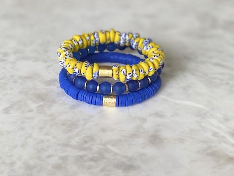 The price listed is for 3 custom mix beaded bracelets. 1- Navy blue colored polymer clay beaded bracelet with gold a cylinder accent  1- Navy blue glass round beads with gold spacer accents  1- Handmade yellow and navy blue recycled Sankas glass beads from Ghana Africa  Please request the desired size bracelets you would like in the dropdown menu above when placing your order. These beautiful elastic bracelets are made with a durable stretchy cord. Message me for any additional questions! Happy Marble And Gold, Elastic Bracelet, Glass Beaded Bracelets, Gold Glass, Polymer Clay Beads, Ghana, Clay Beads, Stretch Bracelets, Blue Glass