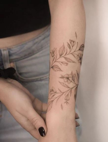 Leaf Tattoo Meaning With 50+ Tattoo Images For Inspiration Botanical Arm Band Tattoo, Leaf Bracelet Tattoo, Leaf Wrap Around Tattoo Arm, Vine Forearm Tattoo, Leaf Tattoo Meaning, Oak Leaf Tattoos, Dogwood Tattoo, Olive Tattoo, Boho Tattoo