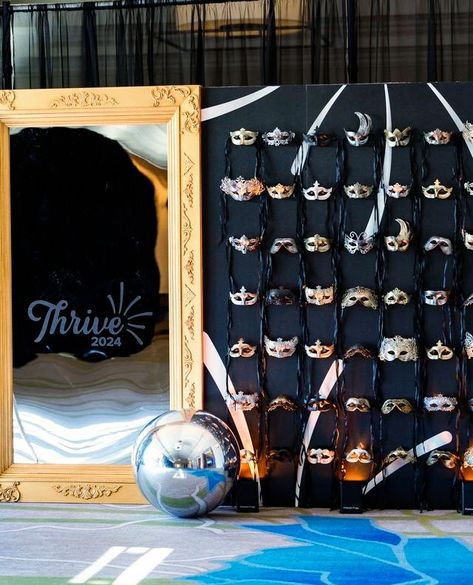 Elegance and mystery in every detail ✨💫 Behold our custom gold and silver mask wall and vintage framed mirror at the Thrive 2024 event.  #maskwall #masquerade #vintagemirror #mirror #framedmirror #goldmirror #blackandgold #silverandgold #elegantdecor #masqueradedecor #masqueradeball #thrive2024 #golddecor #blackdecor #eventdecor #florida #masks #mask #customdecor #customwall Masquerade Charity Ball, Masquerade Corporate Event, Mirror Themed Party, Masquerade High School Dance, Great Gatsby Activities, Masquerade Diy Decorations, Mardi Gras Masquerade Ball, Mascarade Ball Decor, Prom Themes Masquerade