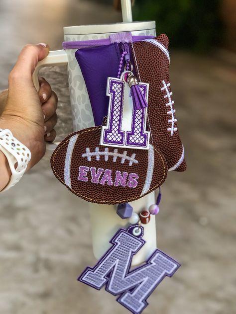 **PLEASE READ!  THIS IS A HIGH DEMAND ITEM AND HAS UP TO A 6-8 WEEK TURNAROUND AT THIS TIME** Could be less, I work orders in order they come in. If this timeline does not work for your please don't order and check back in at a later date SHOW YOUR TEAM SPIRIT! Fully customizable 🏈football🏈 themed bag for your Stanley or other travel mug!  **Price includes custom pouch with personalized football tag and custom number. Add on hanging bottom initial for $15 Choose your team colors, name, initial and number! This zipper pouch is perfect to attach to your favorite tumbler! Great way to carry your, credit cards, cash, chapstick, AirPods, keys and more with your Stanley/Yeti or any brand tumblers ((Pictured on a 40oz Simple Modern tumbler with handle)) NOTE: this listing is for the pouch with Clear Bags For Football Games, Senior Team Gifts, Football Accessories Ideas, Football Mom Bag Essentials, Football Snack Bags For Players, Gifts For Football Coaches, Football Homecoming Gifts For Boys, Football Banquet Gifts For Players, Team Mom Gift Ideas