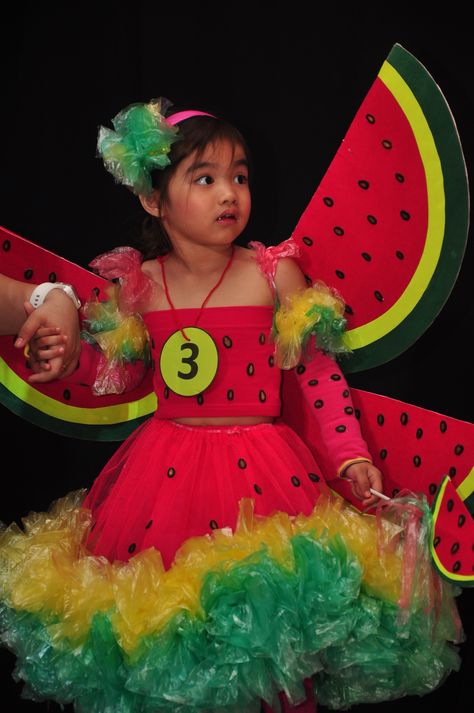 Watermelon princess: made of watermelon seeds as beads, painted cardboard with watermelon seeds, accentuated with plastic bags. :) Vegetable Dress For Kids, Vegetable Costumes For Kids Diy, Watermelon Halloween Costume, Watermelon Fancy Dress For Kids, Recycled Fashion Diy, Watermelon Costume, Pumpkin Princess, Painted Cardboard, Recycled Outfits