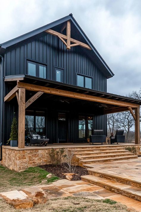 Modern barndominium house black shiplap exterior with dark wood beams. Check out the coolest dark barndominium houses that combine rustic charm with modern sophistication, enhancing a living space with bold hues and sleek designs. Dark Colored Barndominium, Barndominium Siding Ideas, Barndominium Black, Colorado Barndominium, Dark Barndominium, Dark Barndominium Exterior, Dark Modern Farmhouse Exterior, Black Barndominium Exterior, Shiplap Exterior