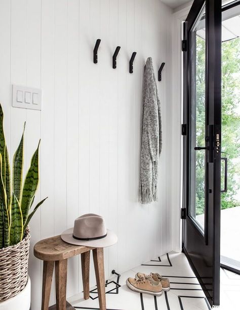 The entrance at the back of the house sets the tone with a graphic black door, beadboard wall and geometric tile underfoot. | Photographer: Kiely Ramos | Designer: Collective Studio    Cozy minimalist wall décor, cozy minimalist entryway, cozy  minimalist bedroom, cozy minimalist home,     Cozy minimalist vibe, cozy minimalist dining room, cozy  minimalist livingroom, cozy minimalist accent wall, cozy minimalist light  fixture, cozy minimalist rugs Black Wall Hooks, Chic Bedroom Design, White Shiplap Wall, Geometric Floor, Hal Decor, Small Entryways, Foyer Design, Shabby Chic Bedroom, Retro Interior