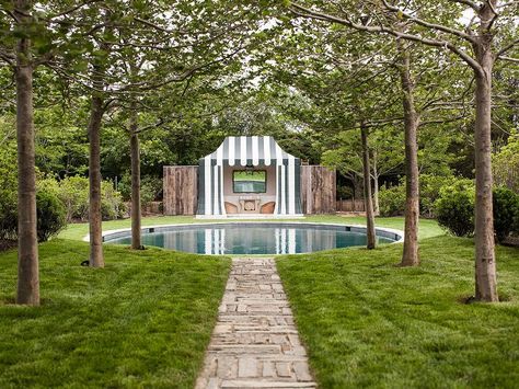 Ethereal garden boasts a round in ground pool placed before a striped pool house filled with wicker chairs and a faux bois mirror. David Netto, Pool With Pool House, Oval Pool, Fire Pit Landscaping, Round Pool, Asian Garden, Modern Backyard, Outside Living, Beautiful Pools