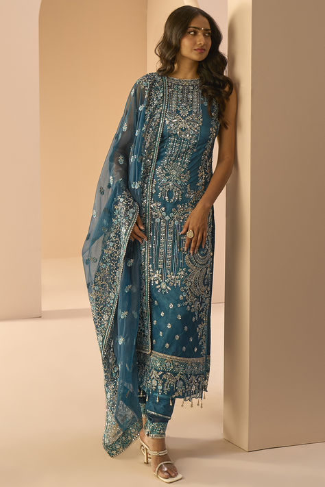 Lashkaraa features a mesmerizing Dark Teal Kurta Set that captivates with its elegance. The eye-catching straight kurta is crafted in net with zari, stone and sequins embroidery. It is paired with satin pants and a net dupatta. for festive occasions or sangeet ceremonies #Perniaspopupshop #womenswear #ethnic #whatiworewastrending #ppuslove #kurtaset #net #sequins #satin #stoneembroidery #zariembroidery #weddingwear #engagement #rawsilk #festivewear #embroiderdkurta #colouroftheyearpeach Teal Suit, Net Embroidery, Straight Suit, Eid Outfits, Kurta Dress, Embroidered Pants, Teal Fabric, Net Dupatta, Indian Fashion Designers