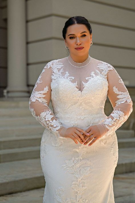 An extraordinary plus-size wedding dress exudes sophistication with a godet silhouette, long sleeves, and a unique flower-shaped train. The royal satin waist corset features an exquisite collar for a unique touch. The buttoned back adds classic beauty, while lace embellishments, beads, and sequins create a princess-like appearance. This dress leaves a lasting impression, making the bride look like royalty on her wedding day. Long Sleeve Wedding Dress Ball Gown, Wedding Dresses Ball Gown Princess, Plus Size Wedding Dresses With Sleeves, Baju Kahwin, Big Wedding Dresses, Plus Size Wedding Gowns, Waist Corset, Ball Gowns Princess, Curvy Bride