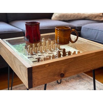 This rustic chess table is a perfect gift for any chess or checkers lover. The finely-detailed chess table features a removable tempered glass top which allows you to "pause" a great game for a break, functioning as a durable coffee or end table surface for drinks, food, and everyday use. When you're ready to step back into the game, the glass top easily slides off and you're ready to play. The table is framed using rustic stained and clear-coated pine. 4 sturdy steel hairpin legs provide plenty Checkers Table, Chess Board Table, Coffee Table Height, Glass Top End Tables, Puzzle Table, Chess Table, Studio Table, Wood Joinery, Glass Top Coffee Table