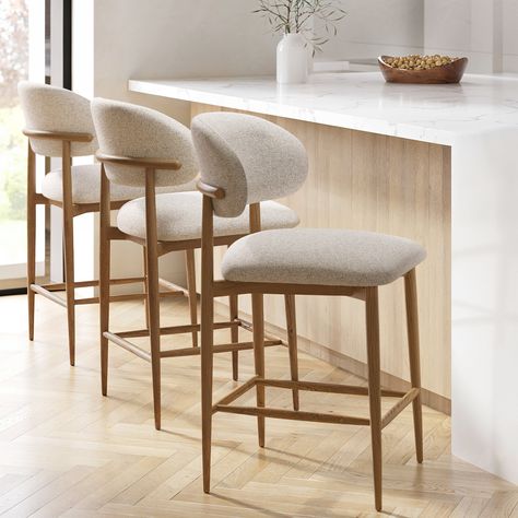 All about meUpholstered in a beige textured fabric the Kori kitchen stool brings a mid-century modern flair to your kitchen area and is easy to style with different kitchen furniture. The exposed oak back detail adds a modern stylish touch. Designed to look and feel good the foam filled seat and curved back rest provide the ultimate comfort. Complete with a solid oak frame this stool is built to lastNeed to know . Number of chairs .  3 Dimensions .  W49.8 x D57.5 x H95cm Product Weight .  8kg Fi Scandi Kitchen Bar Stools, Neutral Kitchen Bar Stools, Breakfast Bar Stools With Backs, Neutral Bar Stools, Minimalist Bar Stools, Kitchen Stools For Island, Barstools In Kitchen, Kitchen Bar Stools With Backs, Kitchen Island Stools With Backs