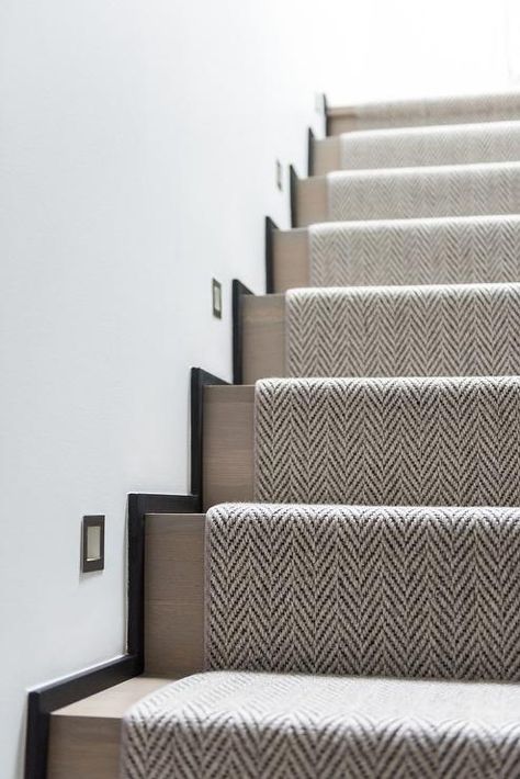 A woven herringbone rug accents a gray wash staircase illuminated by inset lights. Stairs Lighting, Carpet Staircase, Herringbone Rug, Staircase Runner, Staircase Remodel, Hallway Designs, Entrance Foyer, Up House, Stair Runner Carpet