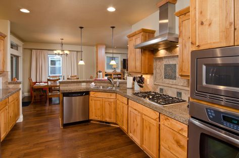 Kitchen with wood floor, oak cabinets, stove, hood, and recessed lights Honey Oak Cabinets With Brass Hardware, Vinyl Plank Flooring With Honey Oak Trim, Early American Stain On Oak Cabinets, Hardwood Floors With Oak Cabinets, Oak Cabinets With Dark Floors, Honey Oak Cabinets With Dark Wood Floors, Wood Floors With Honey Oak Cabinets, What Color Floor With Honey Oak Cabinets, Oak Cabinets With Wood Floors