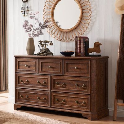 This rustic 7-drawer chest brings a touch of French country charm to your bedroom or living room. The spacious frame is made from engineered wood with the weathered finish of your choice, and it rests on bracket-style feet for a traditional silhouette. With four large drawers and three smaller ones, it offers ample storage for clothes, toys, and books. The classic drop-down hardware handles give it an extra touch of elegance. Beveled edges on the dresser and crown molding give this dresser an ex Vintage Brown Dresser, Cute Wooden Dresser, Brown Dresser Bedroom Ideas, Vintage Dresser Decor, Bedroom Dresser Ideas, Vintage Wooden Furniture, Dark Wood Dresser, Rustic Chest Of Drawers, Farmhouse Bedroom Furniture